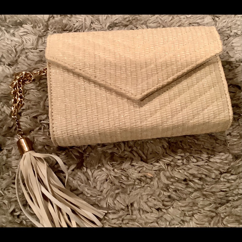 Cream woven clutch with gold straps and tassels. Inside pockets for ID & cards